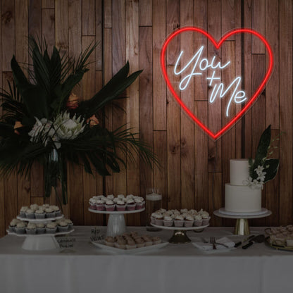 red you and me neon sign hanging on timber wall above dessert table