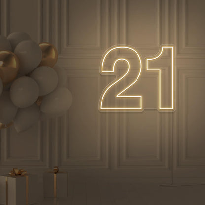 warm white  21 neon sign hanging on wall with balloons