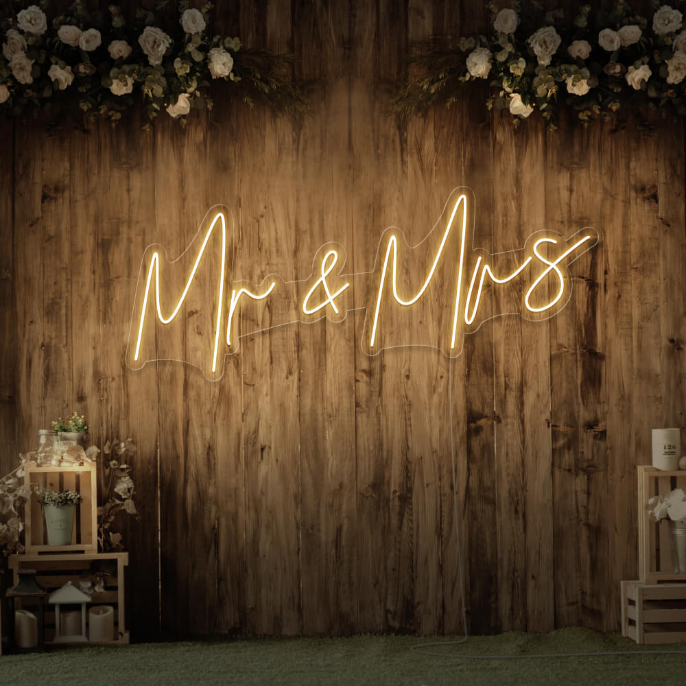 warm white mr and mrs neon sign hanging on wall with flowers