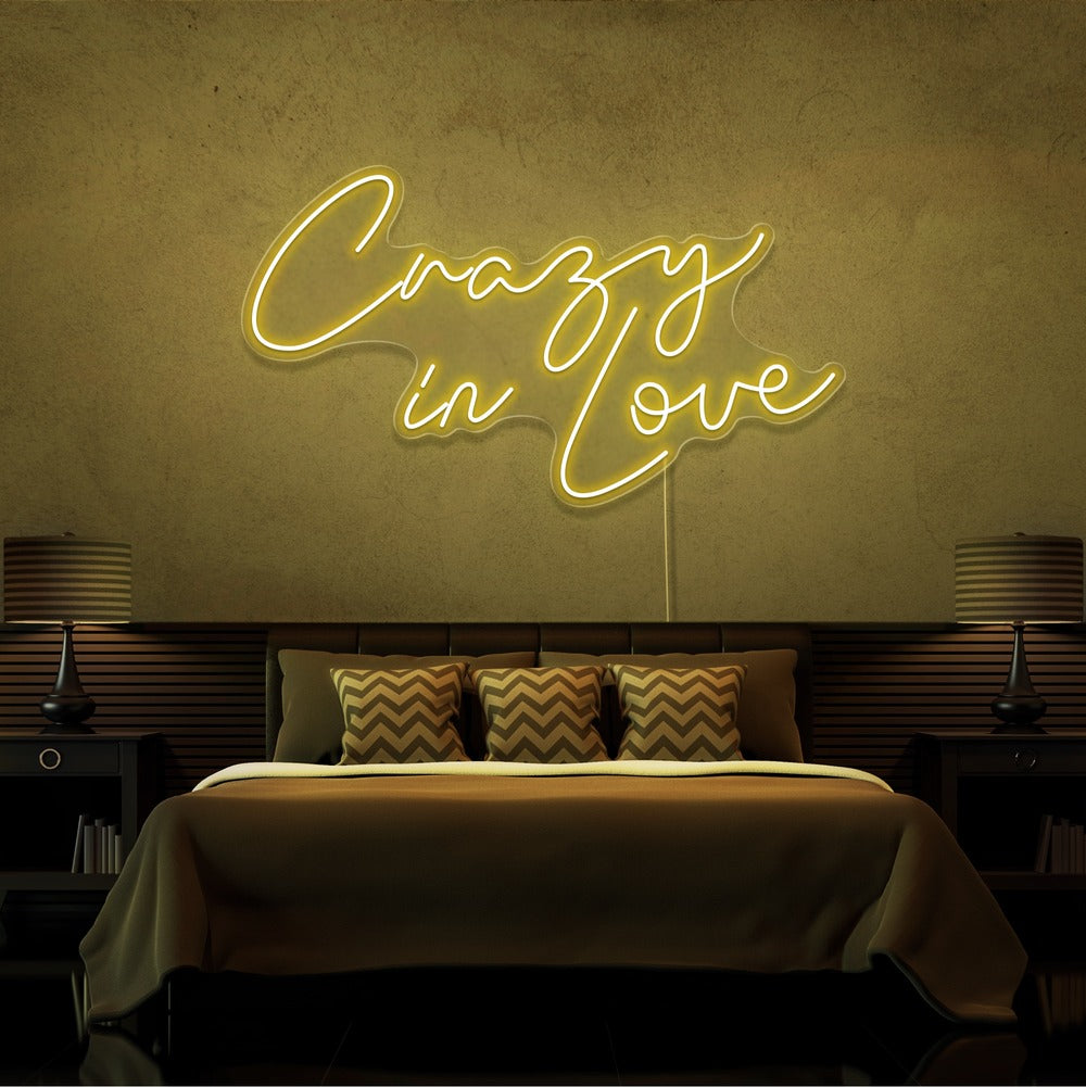 yellow crazy in love neon sign hanging on bedroom wall