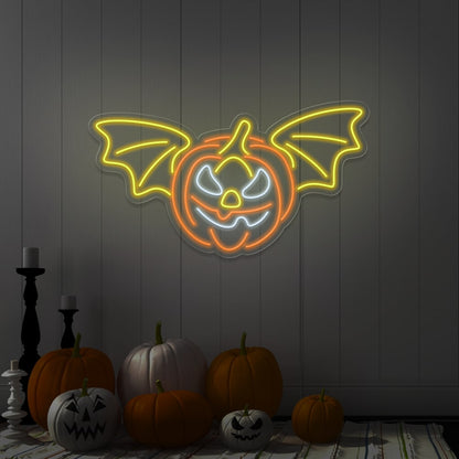 yellow flying pumpkin neon sign hanging on wall above pumpkins