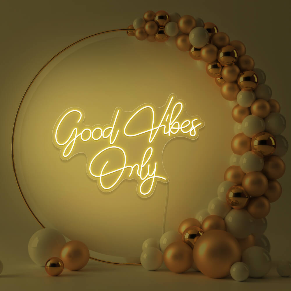 yellow good vibes only neon sign hanging inside balloon hoop backdrop