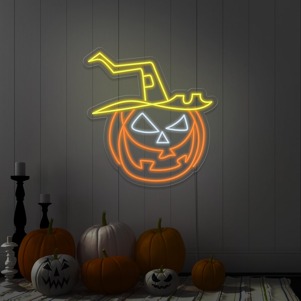 yellow pumpkin hat neon sign hanging on wall next to pumpkins