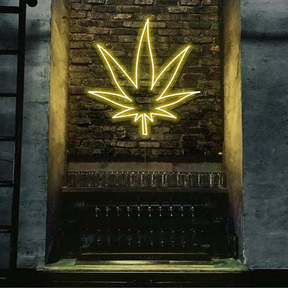 yellow weed leaf neon sign hanging on bar wall