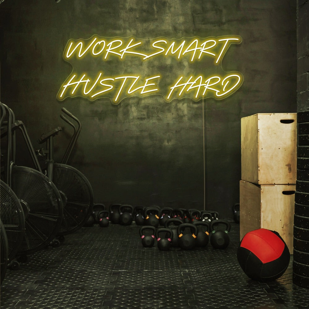 yellow work smart hustle hard neon sign hanging on gym wall