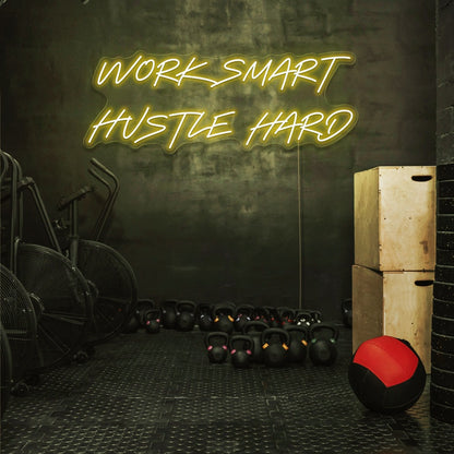 yellow work smart hustle hard neon sign hanging on gym wall